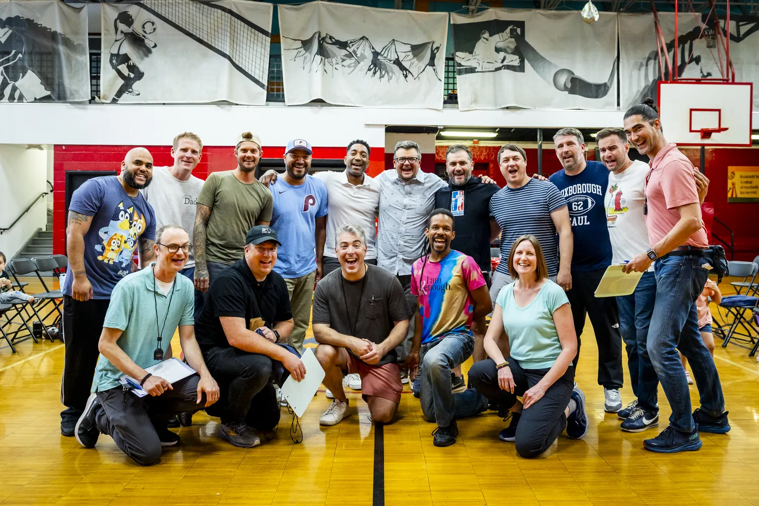 The Dadcathlon competitors and families gathered for a group photo on the gym floor