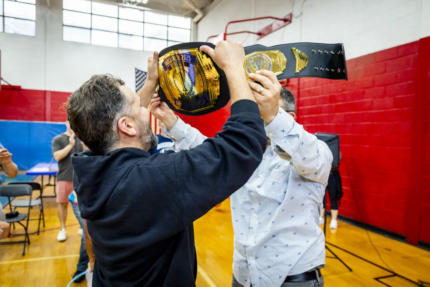 A dad lifting the Dadcathlon championship belt